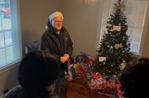 David Page showing family gifts under tree